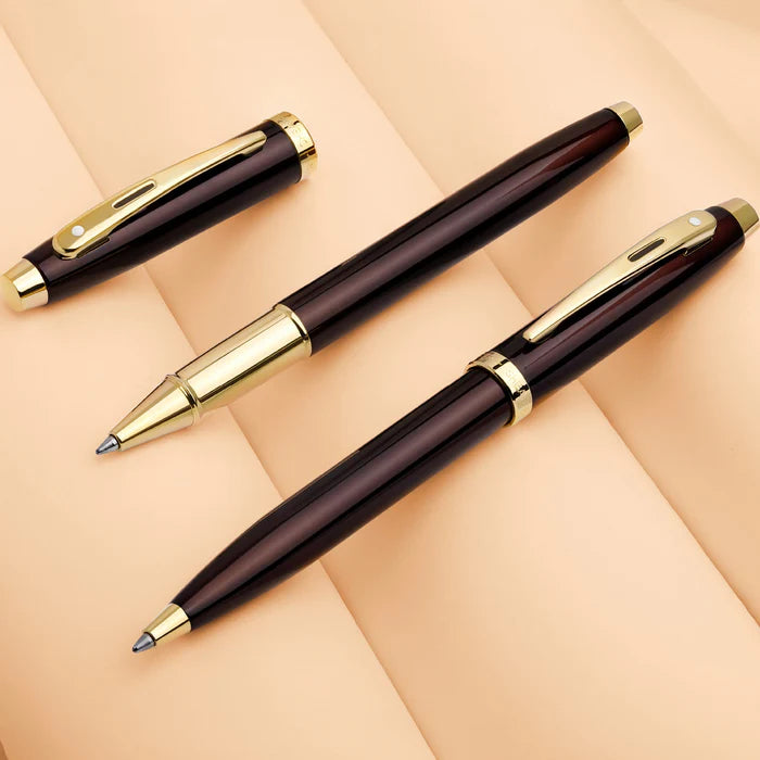 Sheaffer 100 9370 Glossy Coffee Brown Ballpoint Pen With PVD Gold-Tone Trims on a beige background