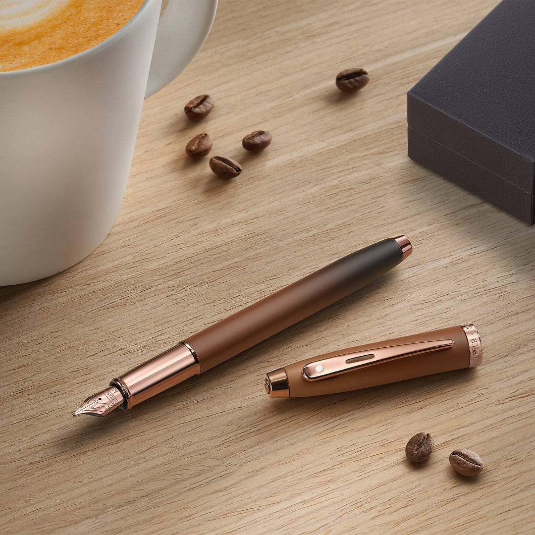 Sheaffer 100 9374 Coffee Edition Matte Brown Fountain Pen with Regal Brown PVD Trims on desk with coffee and gift box