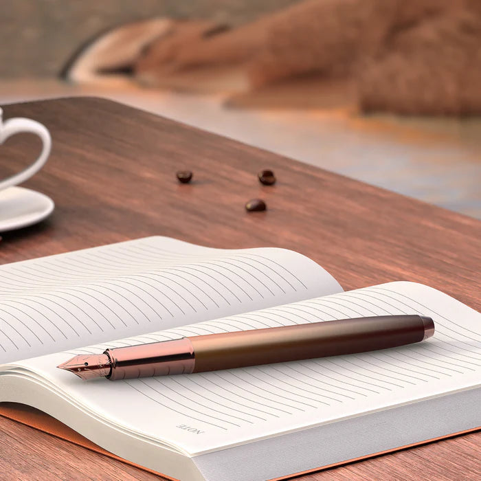 Sheaffer 100 9374 Coffee Edition Matte Brown Fountain Pen with Regal Brown PVD Trims on top of an open planner