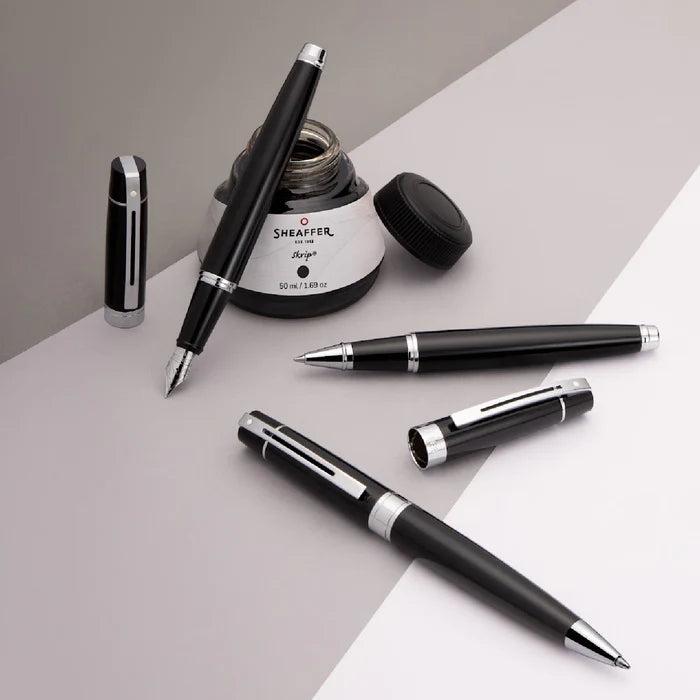 Sheaffer 300 Glossy Black Ballpoint Pens With Chrome Trims on a display platform with sheaffer ink bottle
