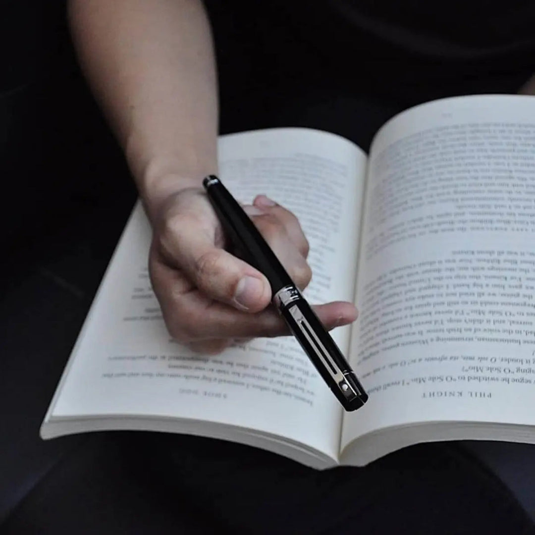 Sheaffer 300 Glossy Black Fountain Pen with Chrome Trims held over open book