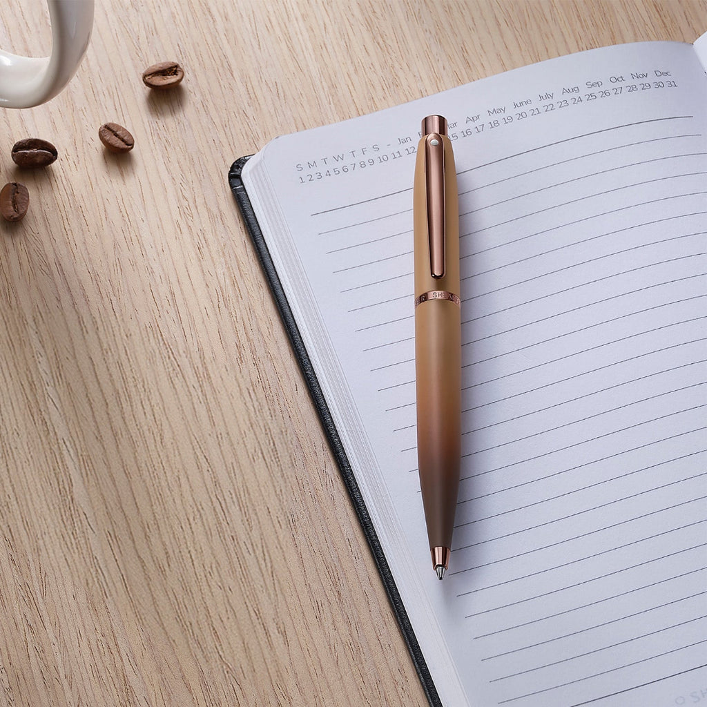 Sheaffer VFM 9428 Coffee Edition Matt Brown Ballpoint Pen with Regal Brown PVD Trims on top of a planner