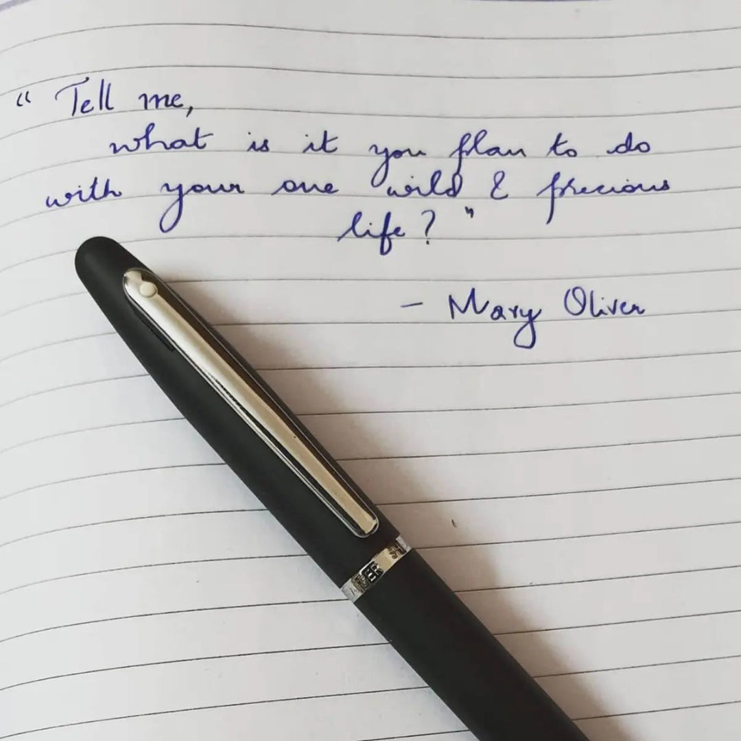 Sheaffer VFM Matte Black Rollerball Pen With Chrome Trims beside a handwritten note